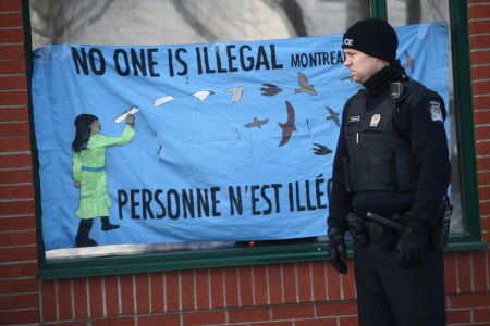 A cop appears impressed by the message that no one is illegal, outside the occupation of Quebec's Education Minister's office. Photo by Arij Riahi